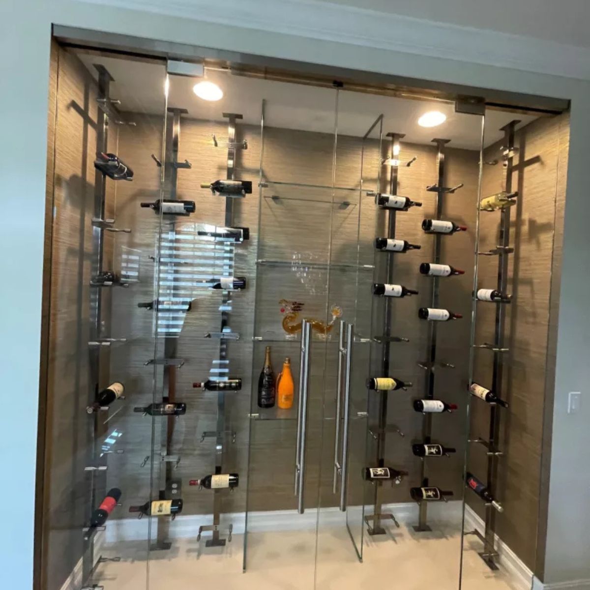 floor-to-ceiling wine rack system behind glass doors with floating bottle display
