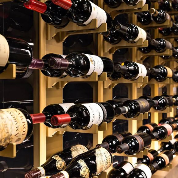 Wine bottles arranged in a wooden wine rack.