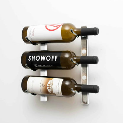 Wall-mounted wine bottle holder with three bottles on a white background