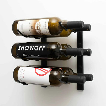 Wall-mounted wine rack holding three bottles of wine on a white background