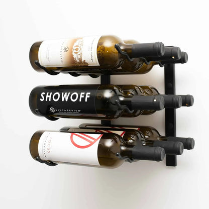 Wall-mounted wine rack holding three bottles of wine on a white background