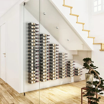 Wine bottles arranged on a wall-mounted rack in a modern interior setting.