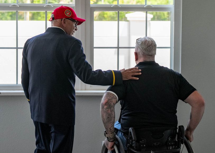 Veteran of war in wheelchair with offical 