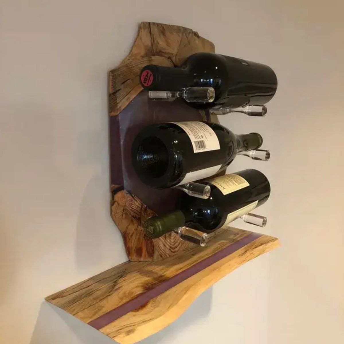 Clear acrylic Vino Pins wine pegs mounted on rustic wood wall holding wine bottles in minimalist display