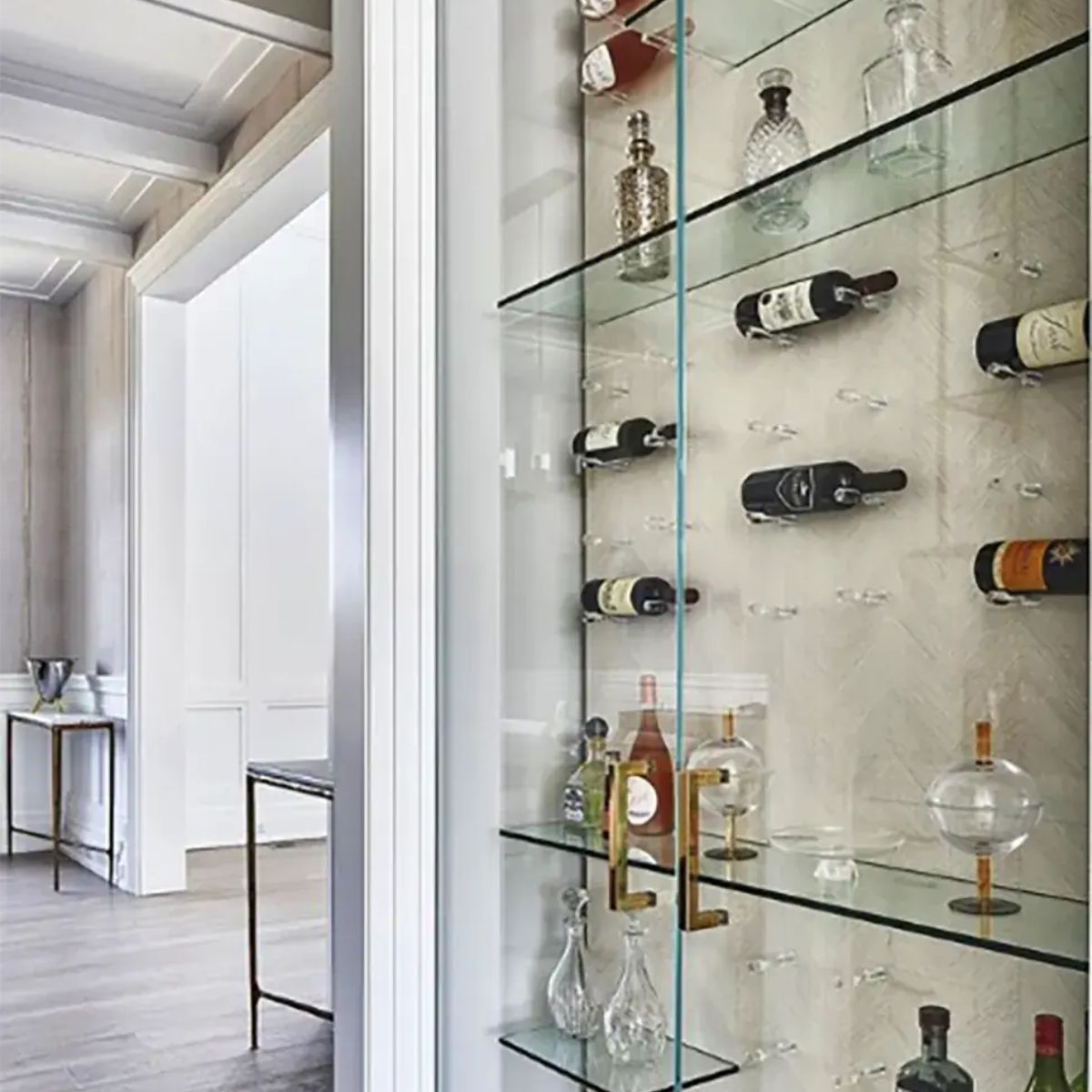 Clear acrylic wine pegs installed inside glass cabinet for floating label-forward wine bottle storage