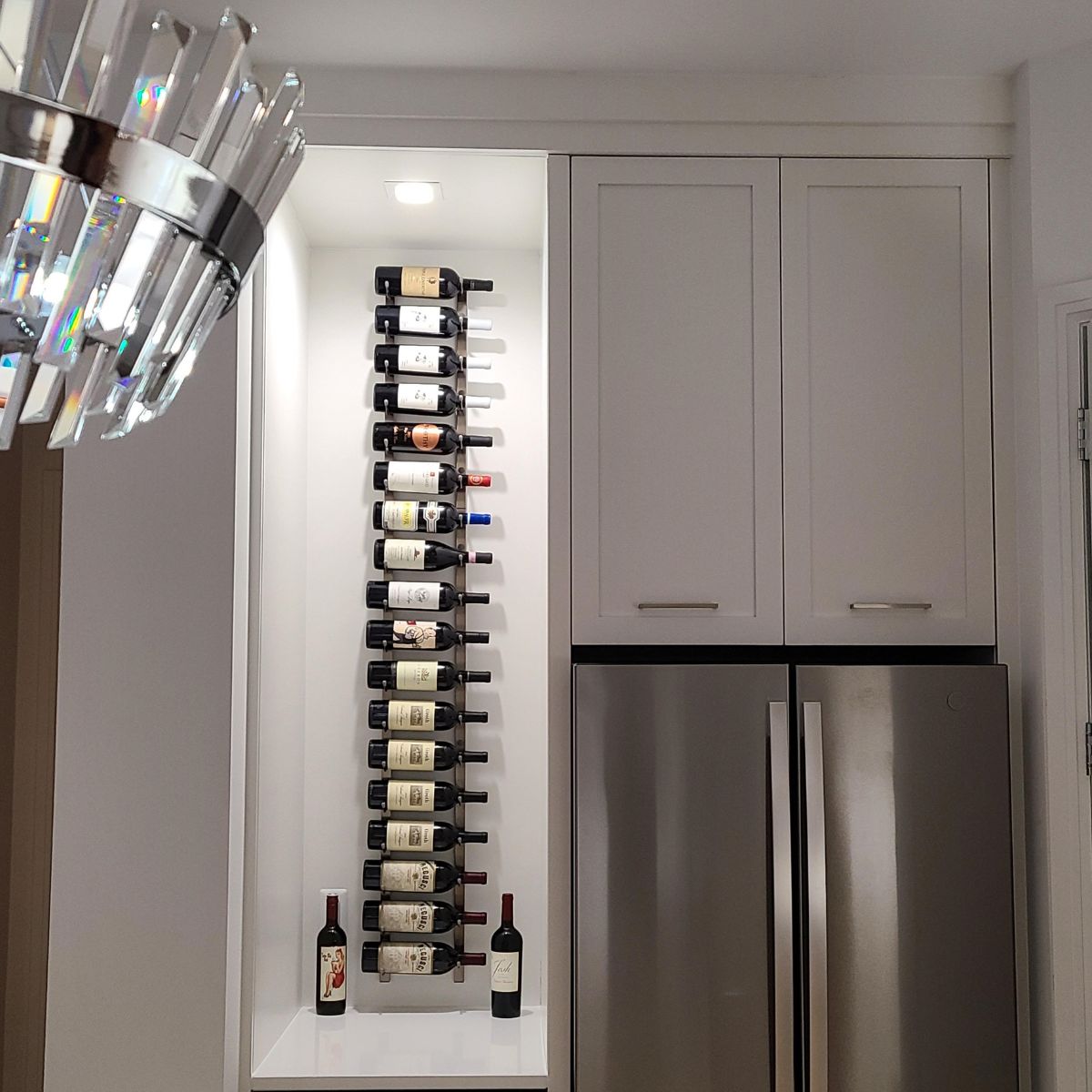 Kitchen with a vertical wine rack against a wall next to a refrigerator.